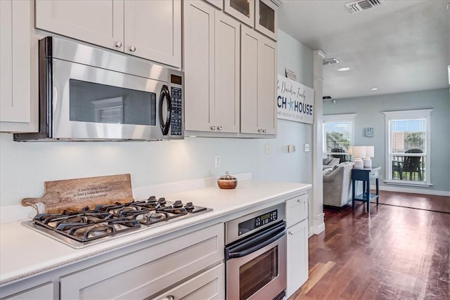 kitchen with white cabinetry, dark hardwood / wood-style floors, and appliances with stainless steel finishes