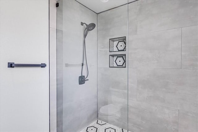 bathroom featuring toilet and tiled shower