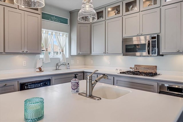 kitchen with pendant lighting, stainless steel appliances, gray cabinetry, and sink