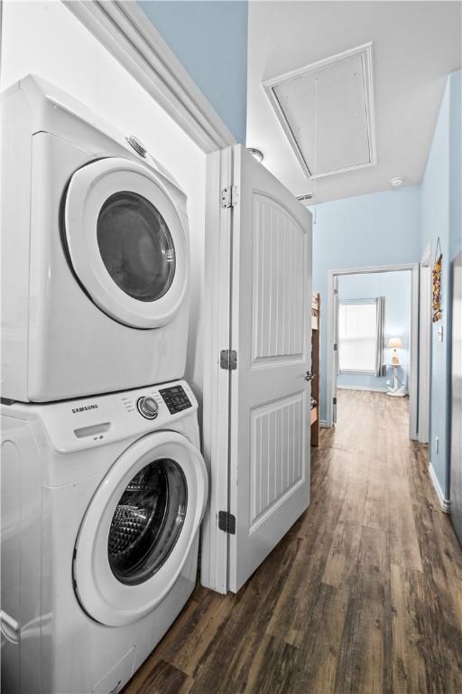 14915 Island Village Dr, Corpus Christi, TX 78418 - washroom featuring attic access, stacked washing machine and dryer, and dark wood-style floors