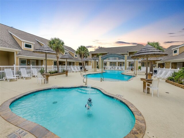 14915 Island Village Dr, Corpus Christi, TX 78418 - pool at dusk featuring a community pool and a patio area
