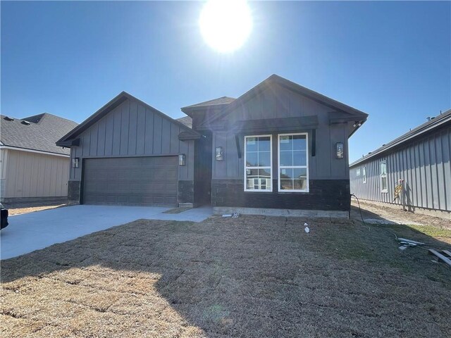 view of front of house with concrete driveway, an attached garage, and board and batten siding