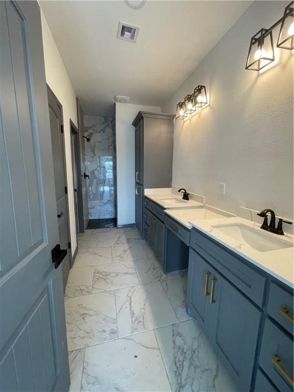 bathroom with visible vents, marble finish floor, a sink, double vanity, and tiled shower