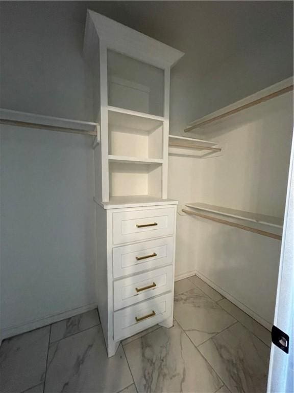 walk in closet with marble finish floor