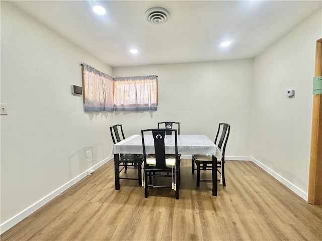 dining area featuring light wood finished floors, visible vents, baseboards, and recessed lighting
