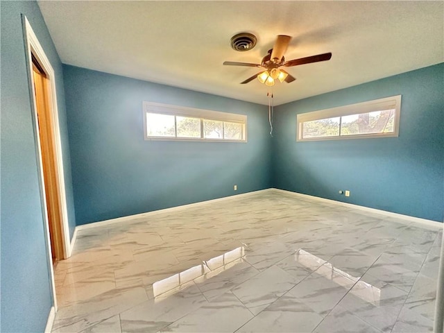 spare room featuring baseboards, a ceiling fan, marble finish floor, and visible vents