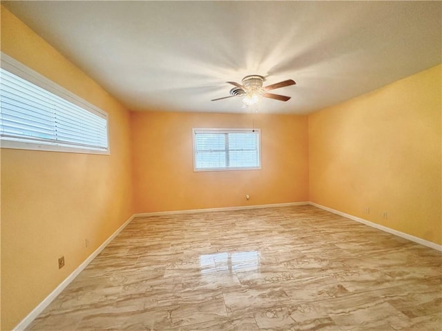 spare room featuring baseboards and a ceiling fan