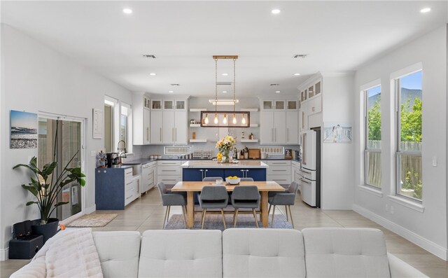 15130 Reales Dr, Corpus Christi, TX 78418 - kitchen featuring high end white refrigerator, tasteful backsplash, white cabinetry, open shelves, and a center island