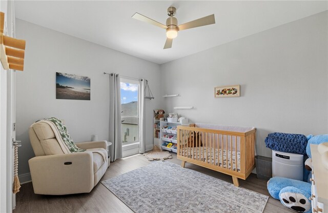 15130 Reales Dr, Corpus Christi, TX 78418 - bedroom featuring wood finished floors, a crib, and a ceiling fan