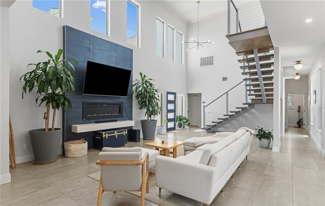 15130 Reales Dr, Corpus Christi, TX 78418 - tiled living area featuring stairs, a towering ceiling, and a chandelier