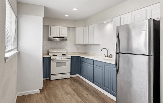 5302 Bonham St, Corpus Christi, TX 78415 - kitchen featuring freestanding refrigerator, white electric stove, under cabinet range hood, a sink, and blue cabinetry