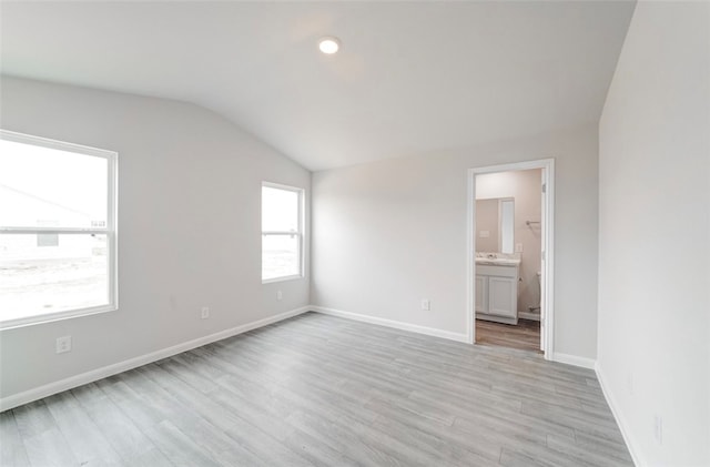 unfurnished room featuring light wood-type flooring and lofted ceiling