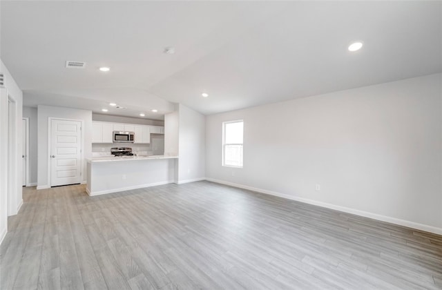 unfurnished living room with light hardwood / wood-style floors and vaulted ceiling