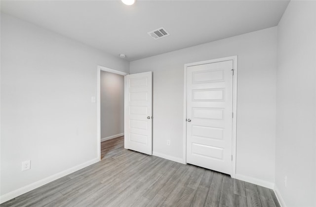 unfurnished bedroom featuring light wood-type flooring and a closet