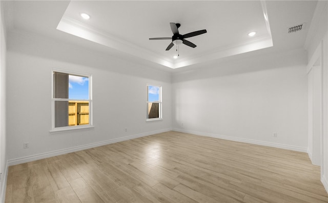 unfurnished room featuring ceiling fan, light wood-type flooring, crown molding, and a tray ceiling