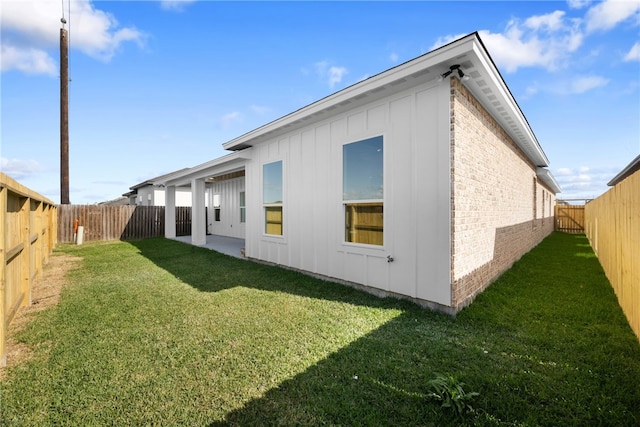 view of side of home with a yard