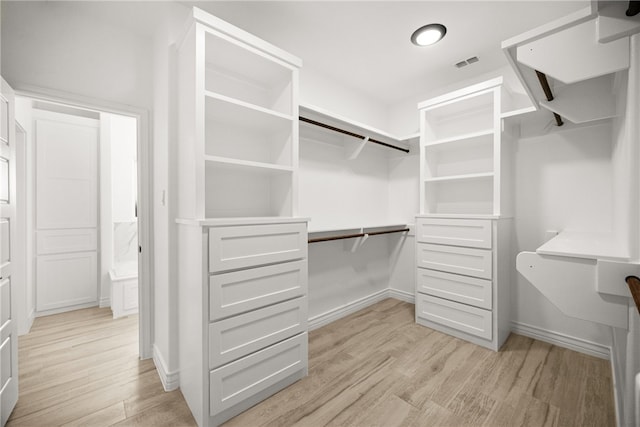 walk in closet with light wood-type flooring