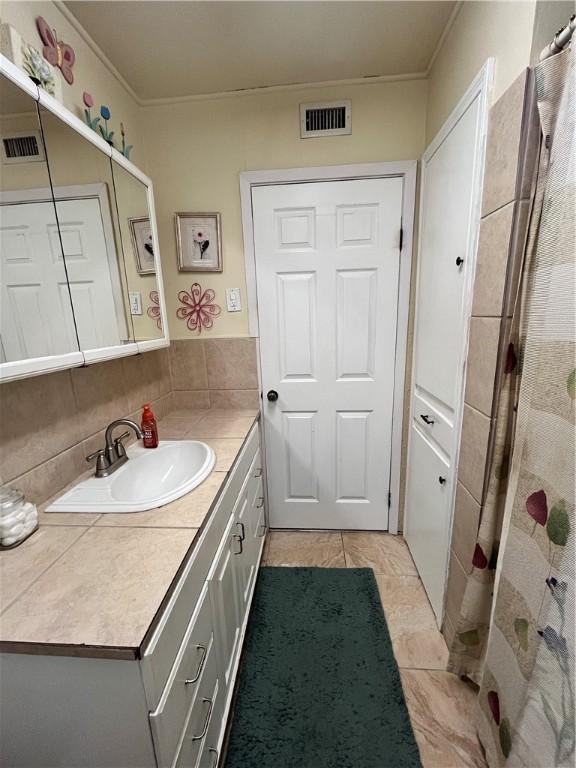 729 Chase Dr, Corpus Christi, TX 78412 - full bathroom featuring vanity, ornamental molding, tile patterned floors, decorative backsplash, and curtained shower