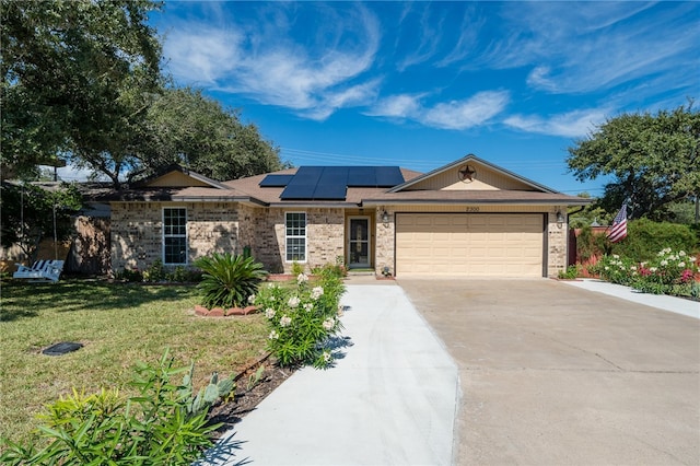 single story home featuring solar panels, a front yard, and a garage