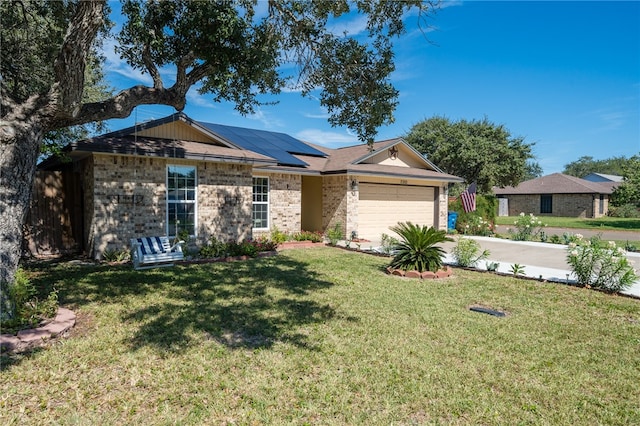 single story home featuring a garage, solar panels, and a front lawn