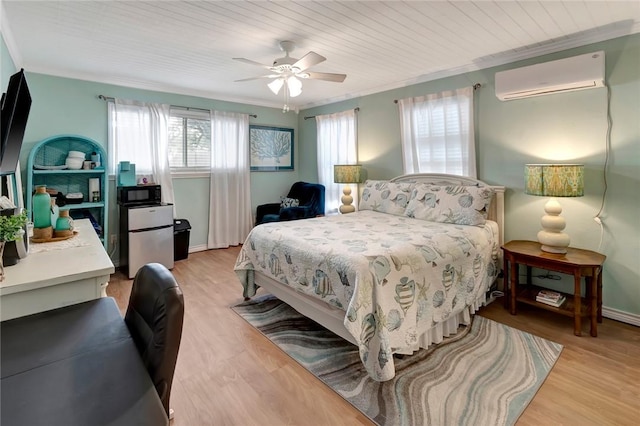 bedroom featuring refrigerator, light wood-type flooring, a wall unit AC, and crown molding