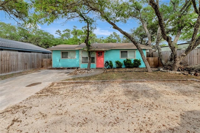 view of front of home featuring driveway and fence