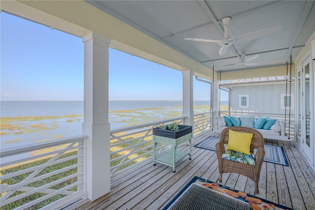 wooden deck featuring a water view and a view of the beach