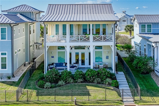 view of front of property with french doors, an outdoor hangout area, a front yard, a balcony, and a patio area