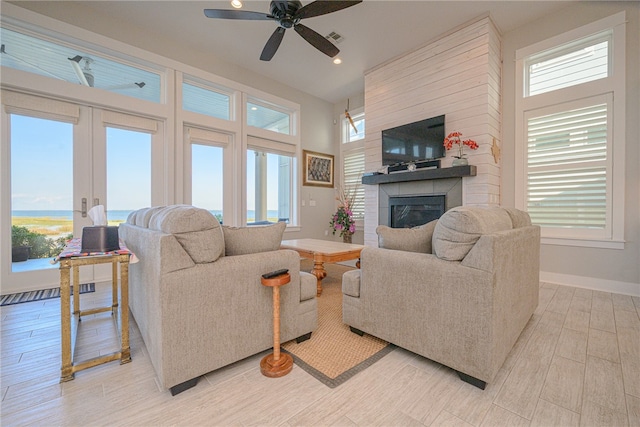 living room with ceiling fan, a fireplace, french doors, and light wood-type flooring