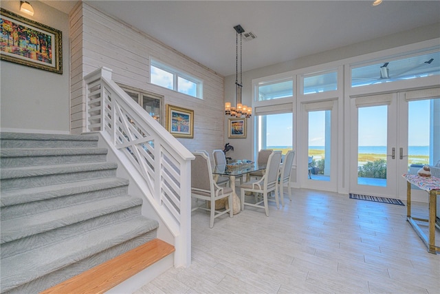 dining room featuring a chandelier, a water view, and french doors