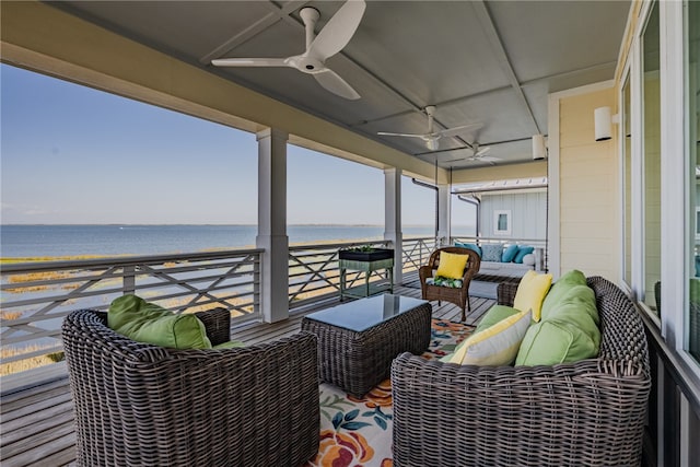 balcony featuring an outdoor living space, ceiling fan, and a water view