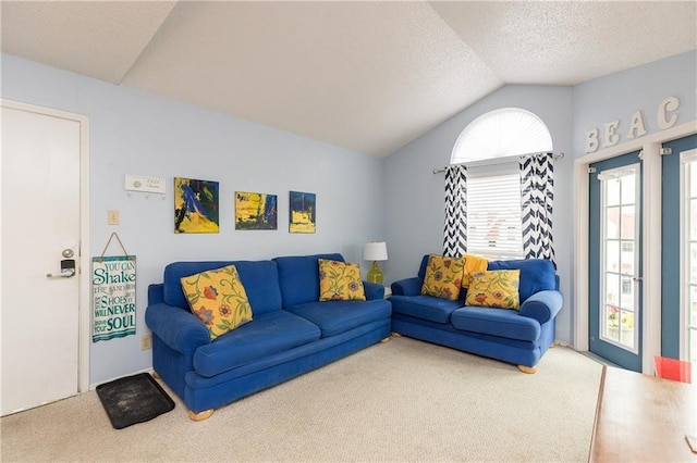 carpeted living area with a textured ceiling and vaulted ceiling