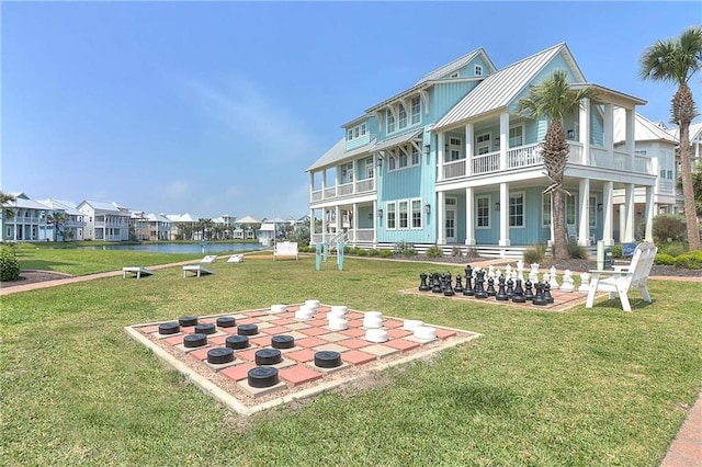 rear view of property featuring a balcony and a lawn