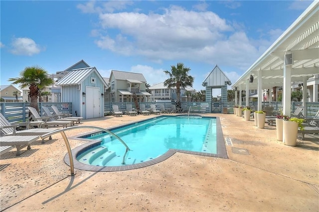 view of swimming pool with a storage unit and a patio area