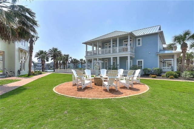 rear view of house with a lawn and a balcony