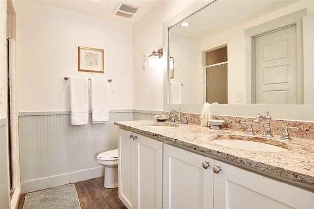 bathroom featuring hardwood / wood-style floors, vanity, toilet, and an enclosed shower