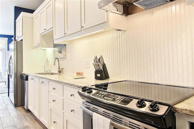 kitchen featuring white cabinetry, sink, light hardwood / wood-style floors, and appliances with stainless steel finishes