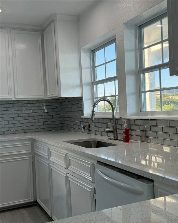 kitchen featuring white cabinets, stainless steel appliances, and light stone counters