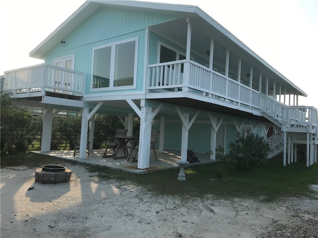 back of house with a patio area, a fire pit, and a wooden deck