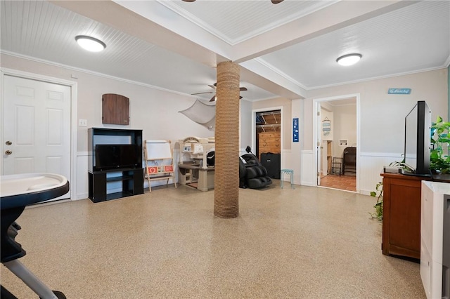 living area with ornate columns, ceiling fan, wainscoting, and ornamental molding