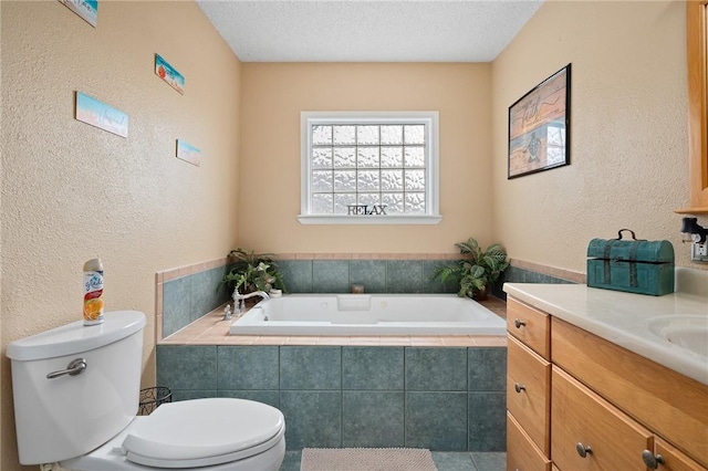 bathroom with vanity, a textured wall, a bath, and toilet