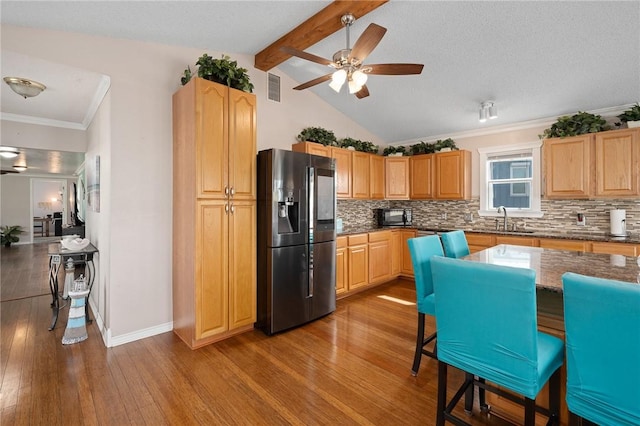 kitchen featuring ceiling fan, visible vents, black microwave, a sink, and refrigerator with ice dispenser