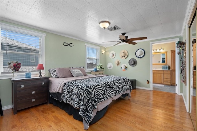 bedroom featuring baseboards, ornamental molding, light wood finished floors, and visible vents