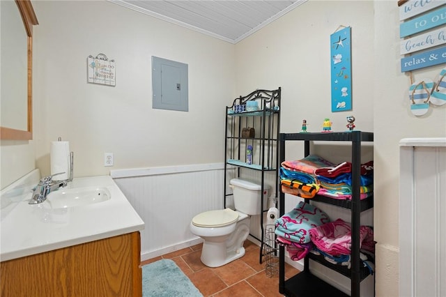 bathroom featuring vanity, ornamental molding, toilet, tile patterned floors, and electric panel