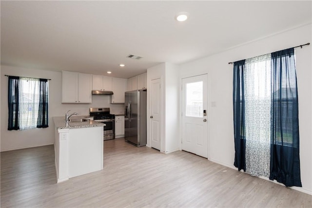 13245 Wrangler St, Robstown, TX 78380 - kitchen featuring a sink, visible vents, light wood finished floors, white cabinets, and appliances with stainless steel finishes