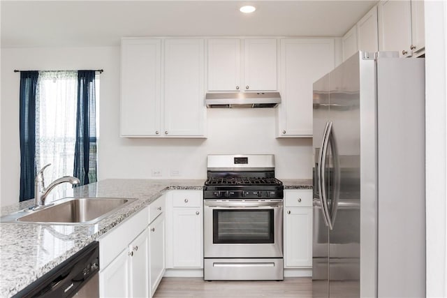 13245 Wrangler St, Robstown, TX 78380 - kitchen with under cabinet range hood, white cabinetry, appliances with stainless steel finishes, and a sink