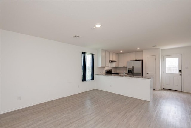 13245 Wrangler St, Robstown, TX 78380 - kitchen featuring a peninsula, visible vents, light wood-style flooring, white cabinets, and appliances with stainless steel finishes