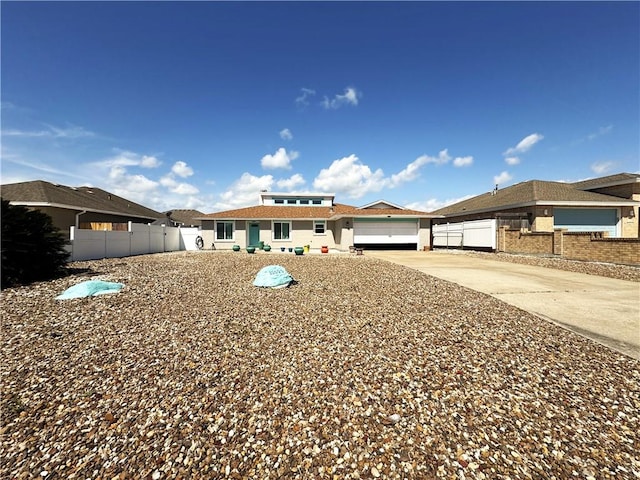 prairie-style home with an attached garage, fence, and driveway