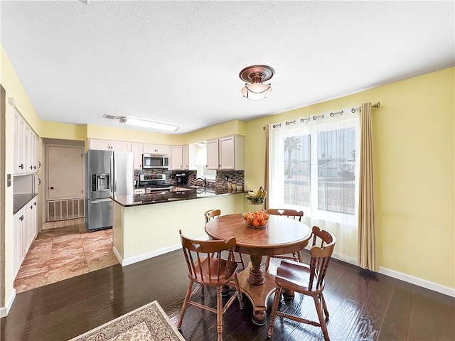 dining space featuring visible vents, baseboards, and wood finished floors