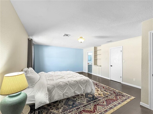 bedroom featuring a textured ceiling, baseboards, and visible vents